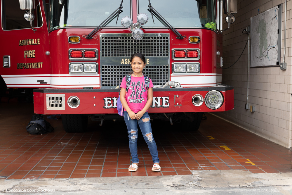 Student standing in front of a fire truck.