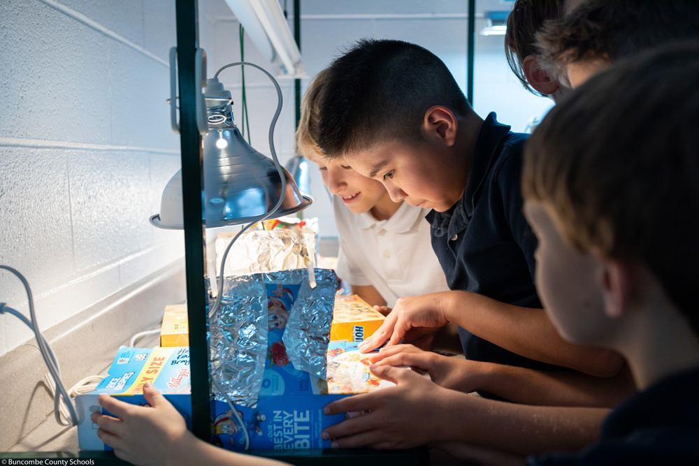 Students peer into their solar ovens