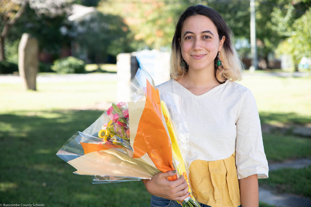 Deema Kahwash standing outside of Community High School with her flowers