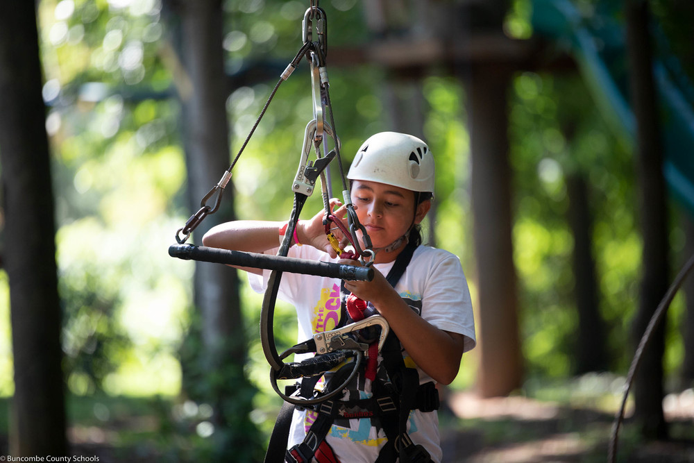 Student completing one of the zipline features at the Asheville Adventure Center