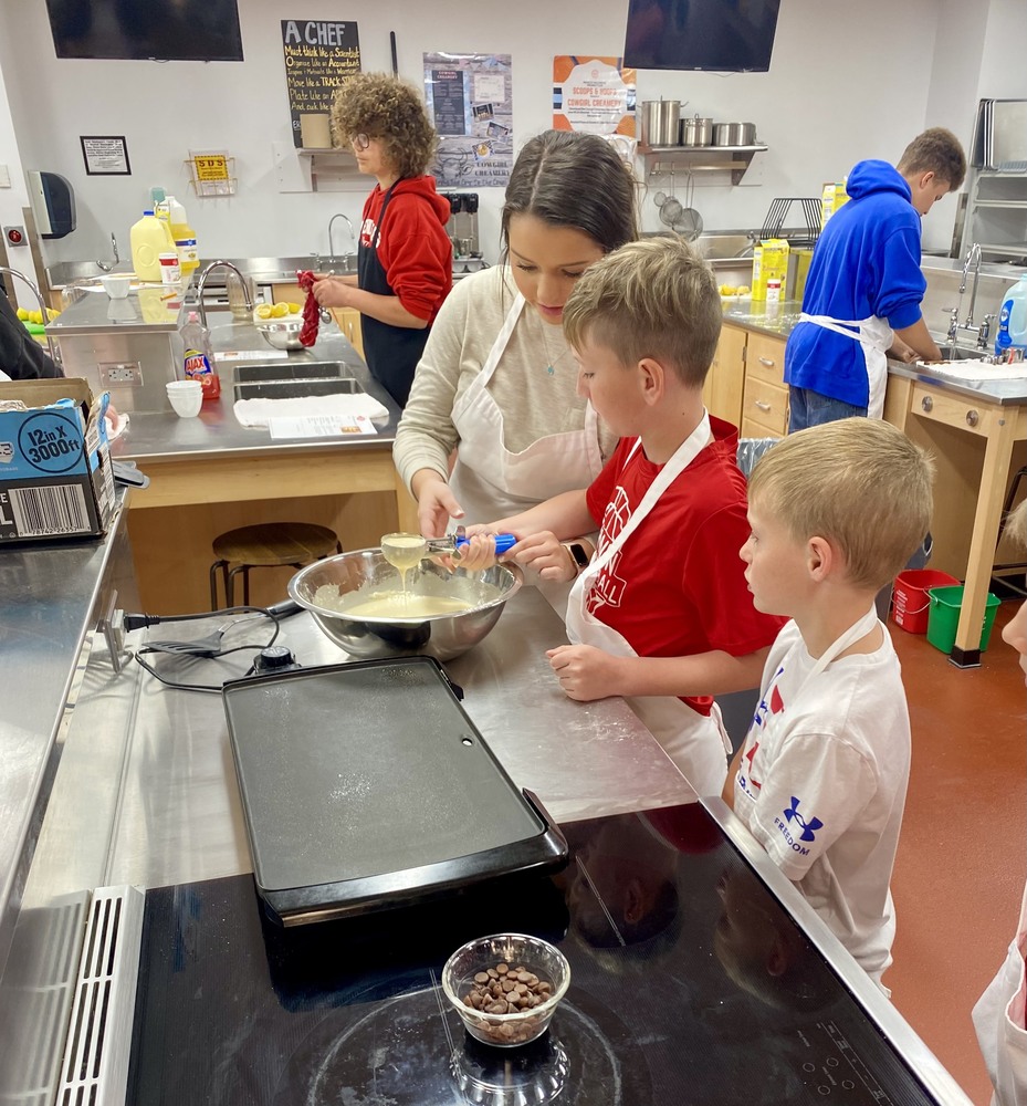 Erwin High students helping the elementary students make pancakes.