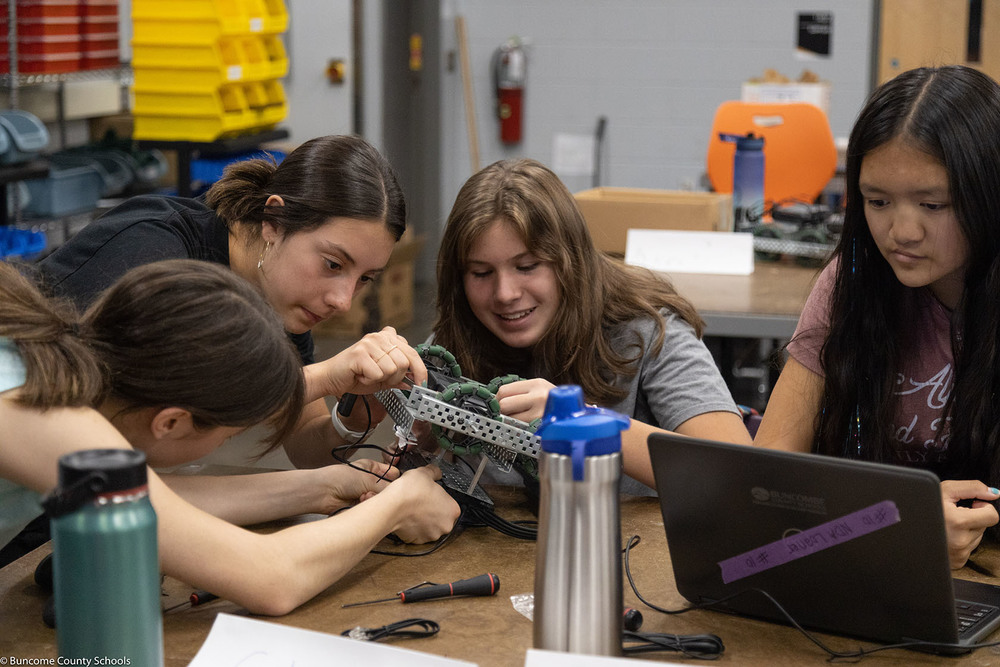female students work on robot
