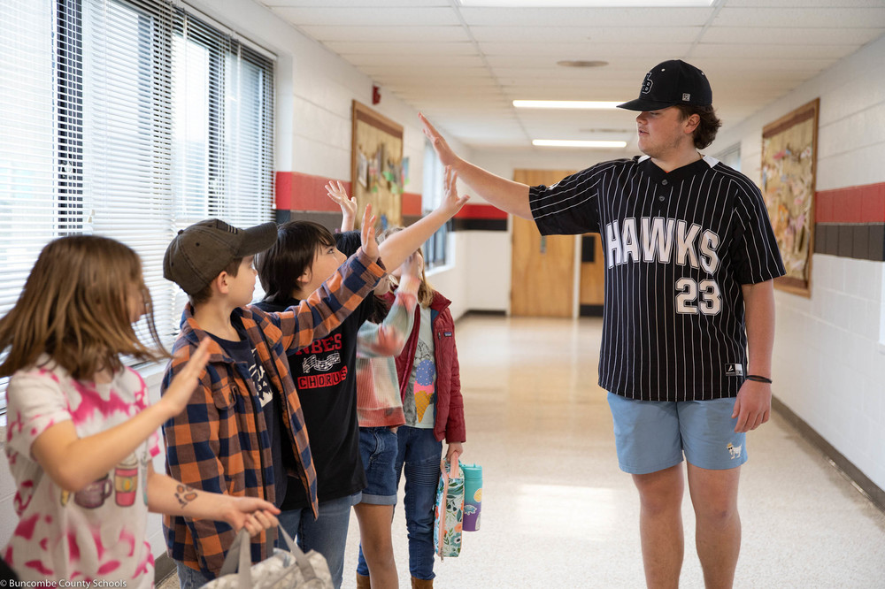North Buncombe High school baseball player giving high fives to students
