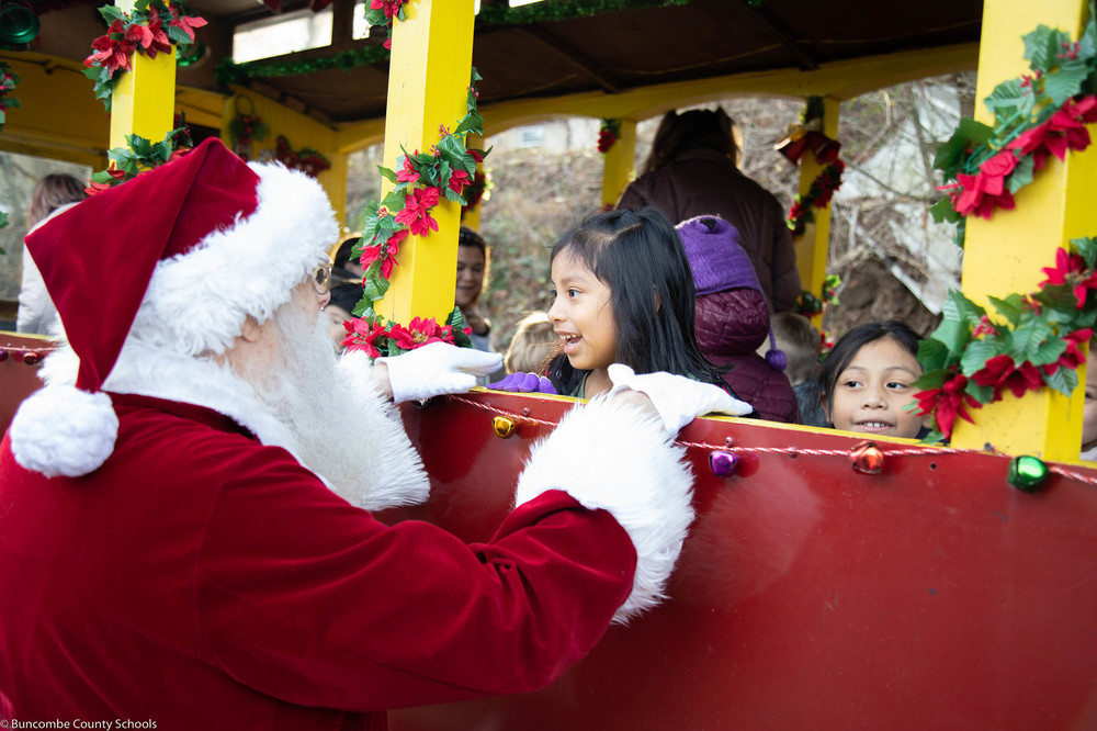 Student siting on the railcar visiting with Santa at the Craggy Mountain Line