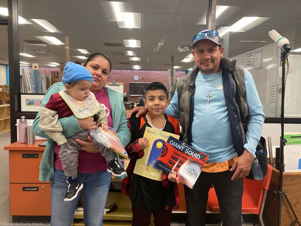 A family poses with books at the event.