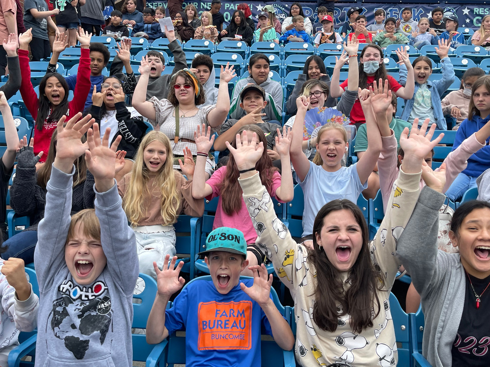 Students cheering for the Asheville Tourists. 