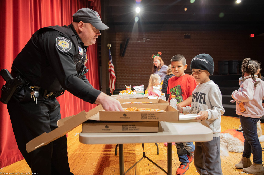 Students being served pizza by SRO Deputy Ryan Justus