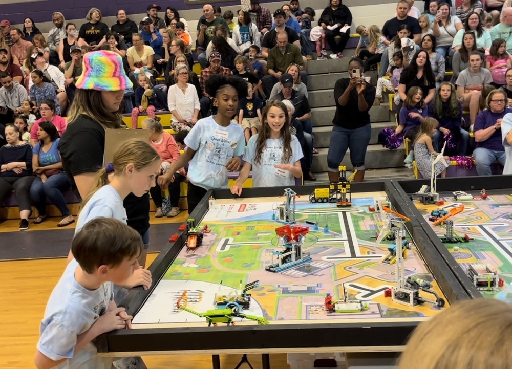 students watching their LEGO robot during competition