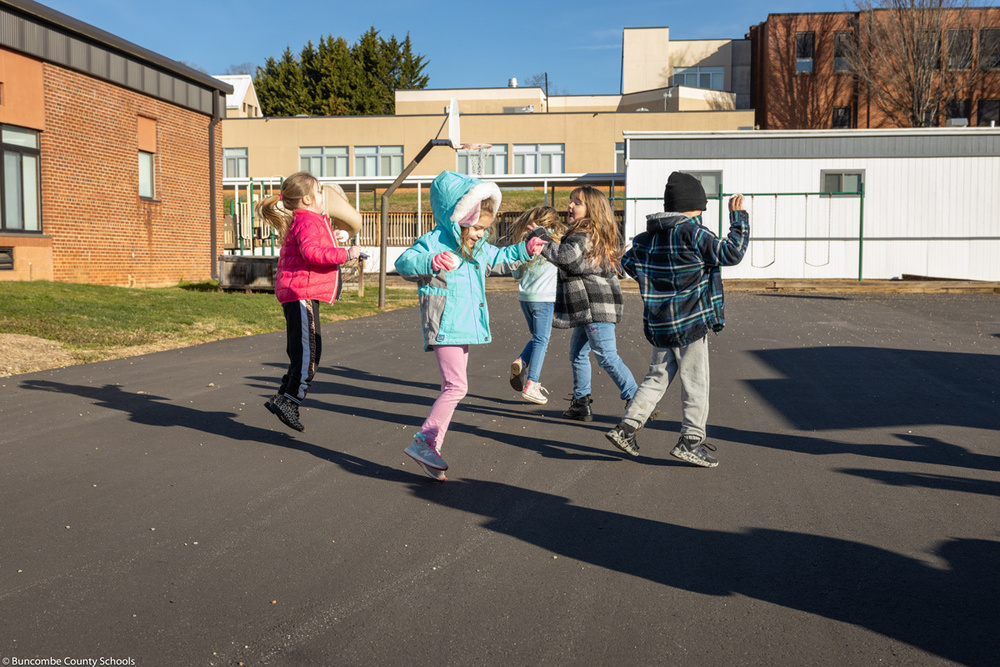 Students run around outside of Leicester Elementary.