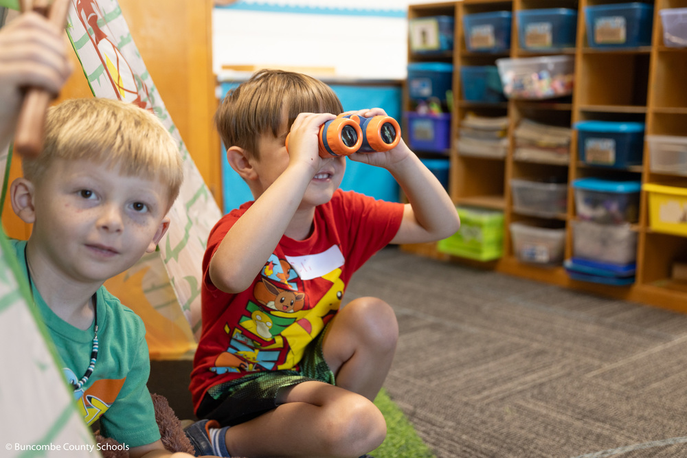 Student looking through child binoculars. 