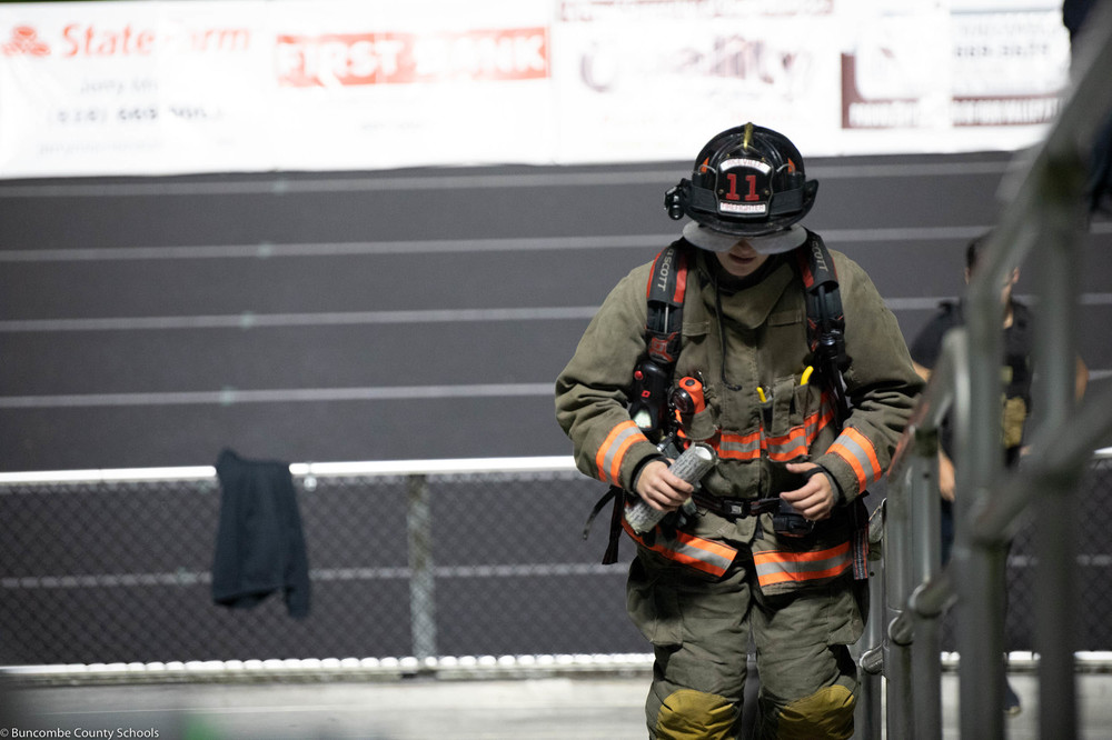 Former student climbing the stairs in his firefighter gear.