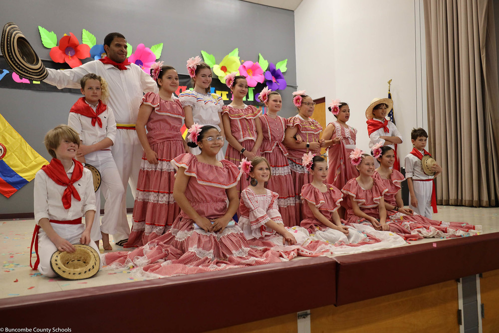 Fifth grade students dressed in their Colombian attire, and posing for a photo.
