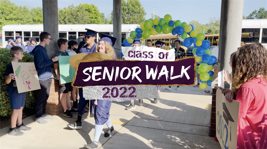 A senior in cap and gown walking