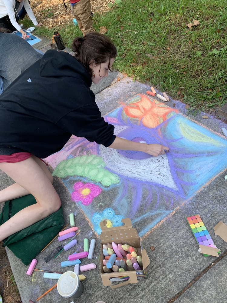 Student creating a mural for Chalk the Walk