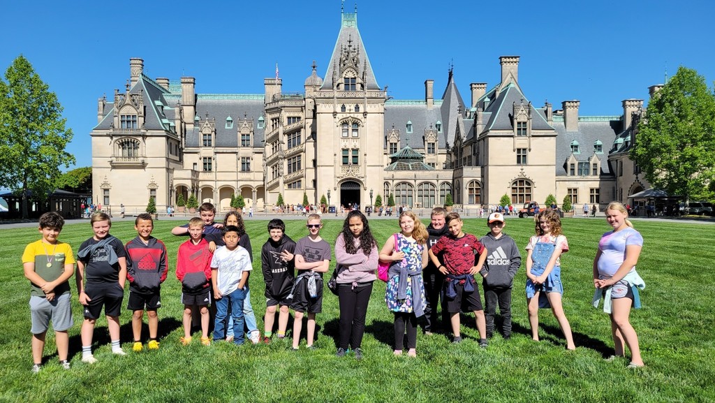 students in a line for picture with biltmore estate in the background