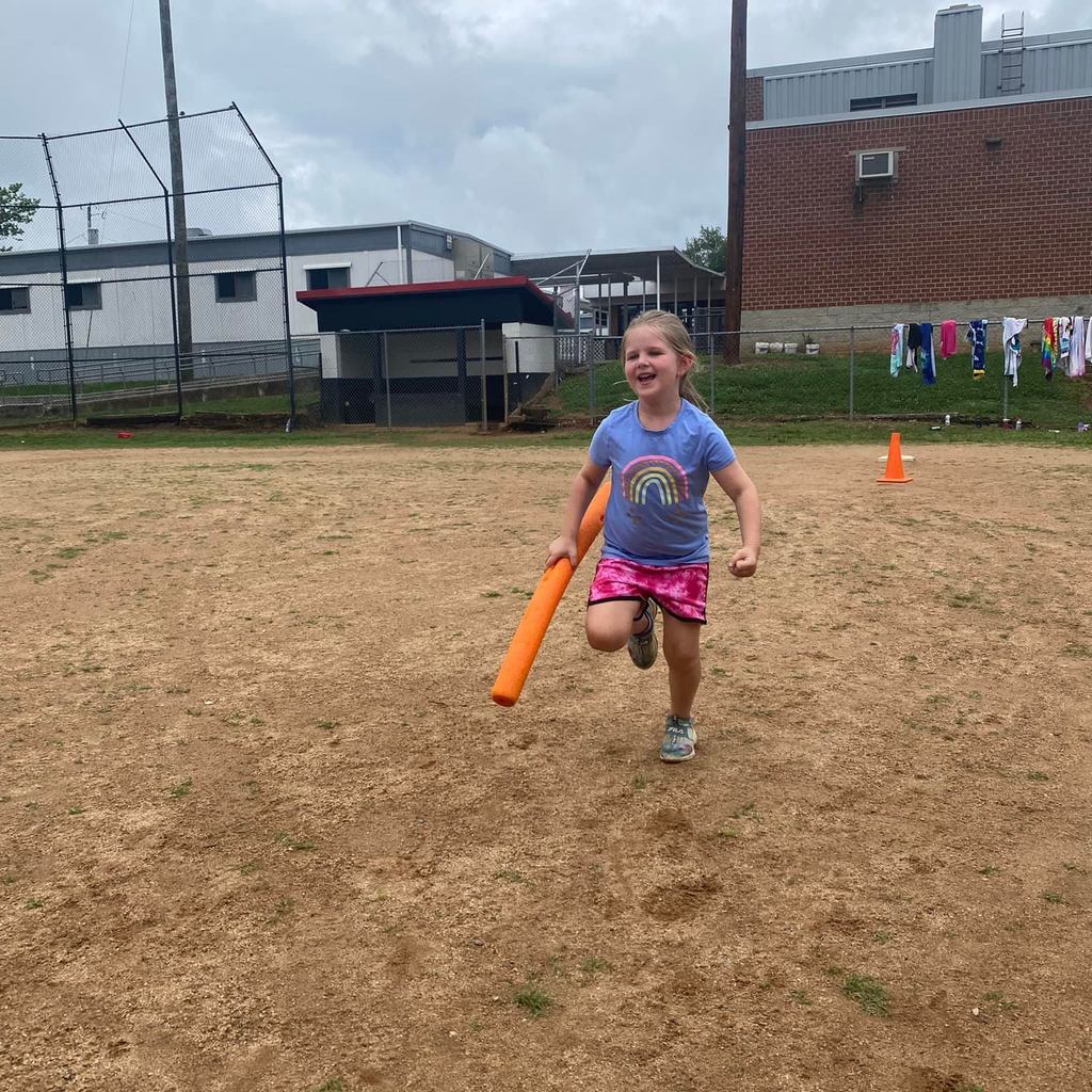 student running on baseball field sand with an orange pool noodle