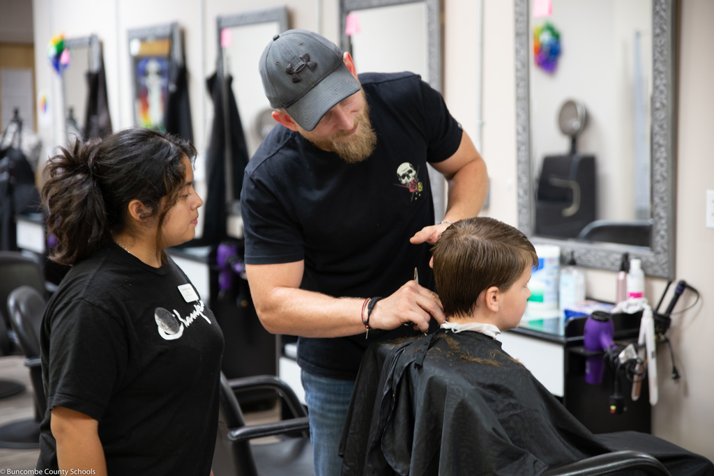 Student and teacher look over child's haircut