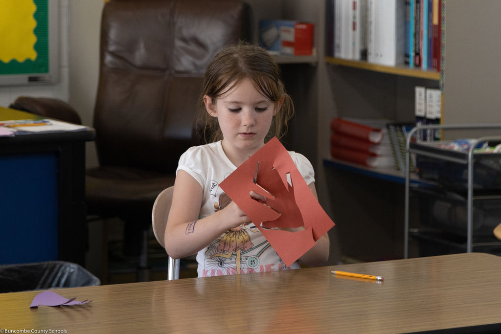 Student cutting out tracing of hand