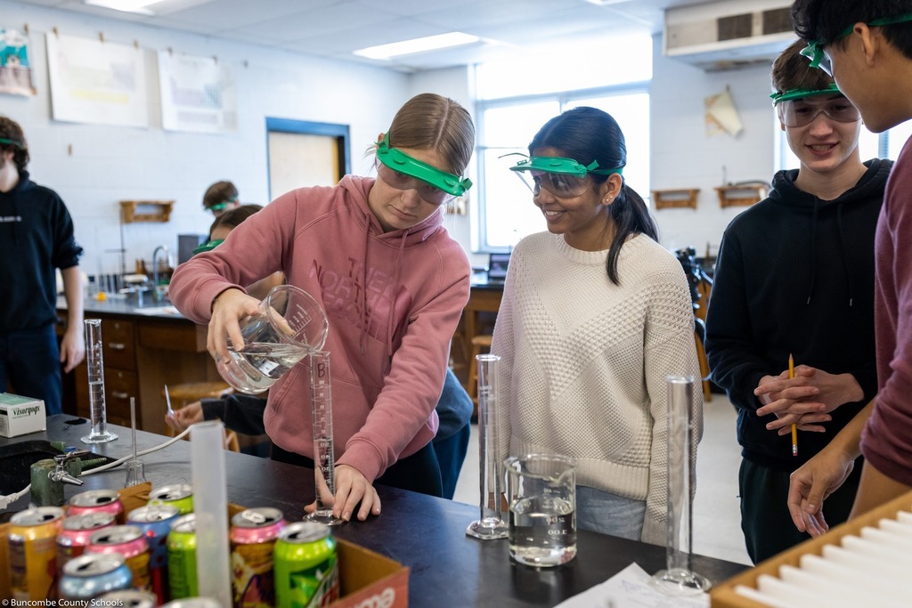 two Students pouring liquid in lab