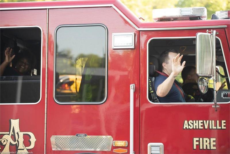 Fire fighters waving from fire truck