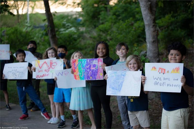 Students holding hand drawn signs