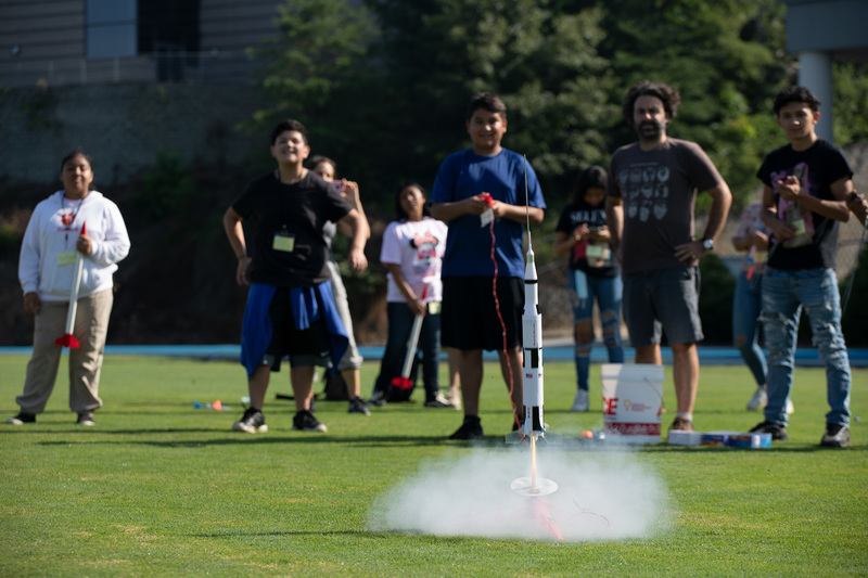Students launching a rocket, and watching in amazement. 