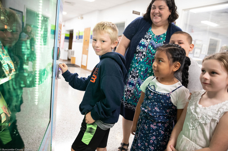 Students trying out the book vending machine for the first time.