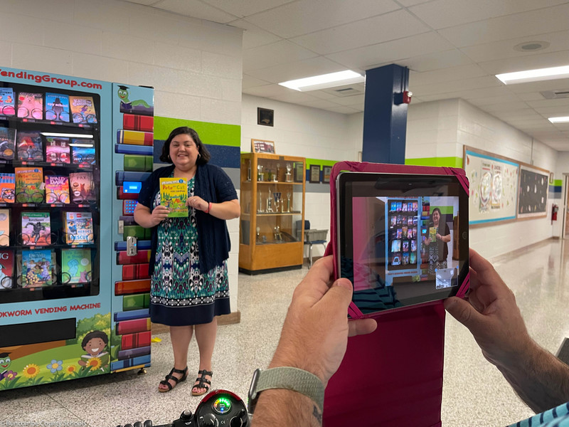 Ms. Lunsford standing at the book vending machine.