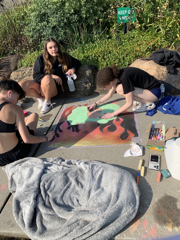 Student creating artwork at the Chalk the Walk event.