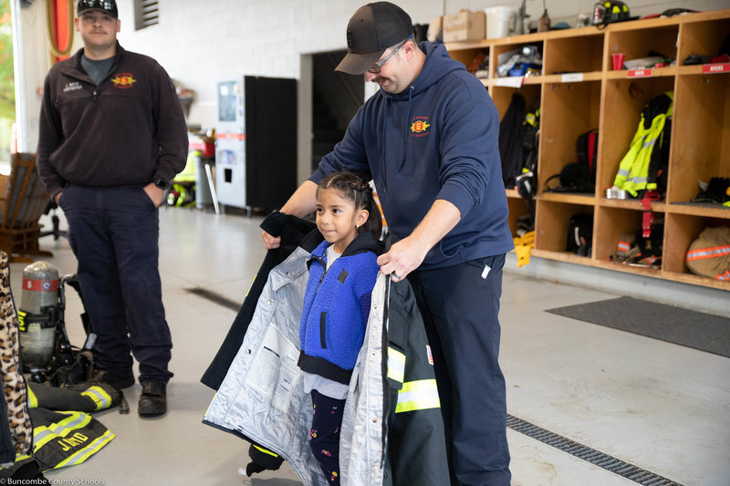 Student trying on a brand new fire jacket.