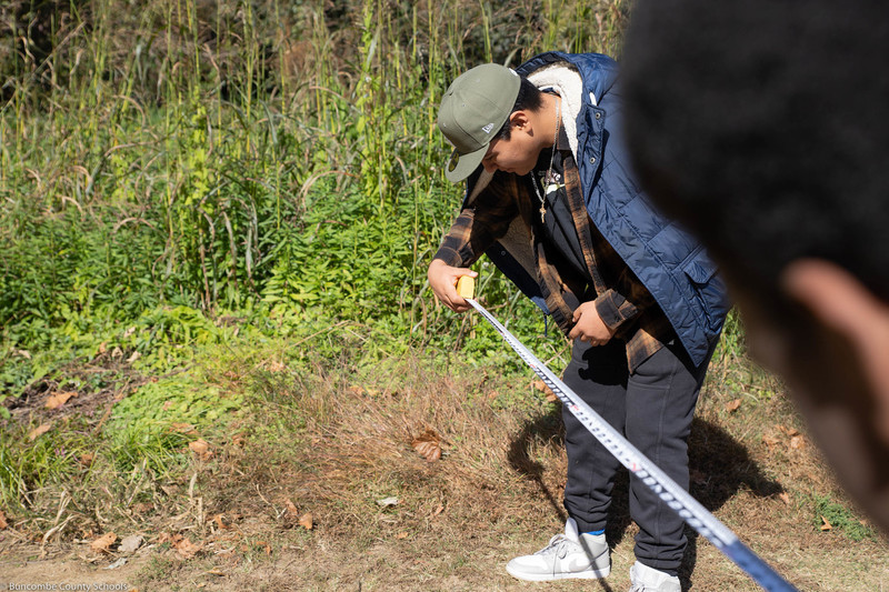 Students measuring an area of the park for future human attraction. 