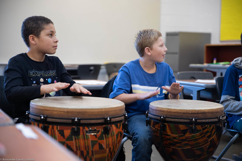 Students making music during drumming club.