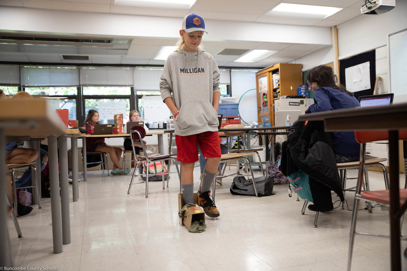 Student demonstrating to the classroom how the walking boot he designed works.