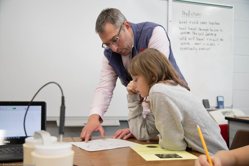 Student getting help from the teacher. 