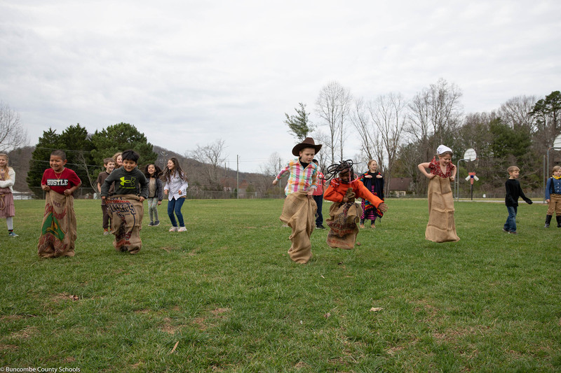 Students having fun in a potato sack race. 