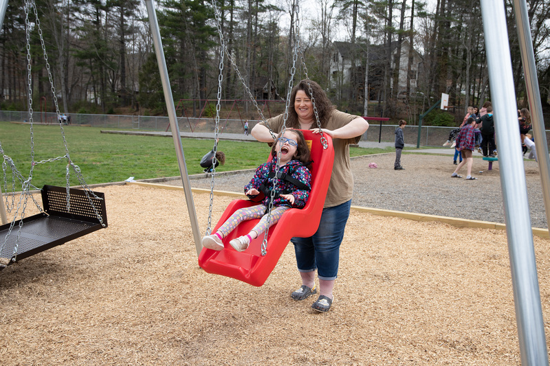 Bella's mom pushing her on the swing.