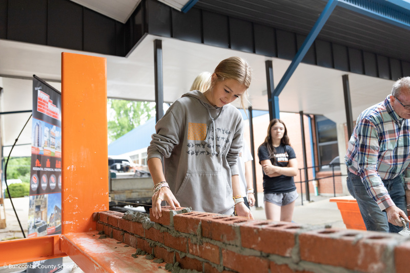 Student laying a brick.