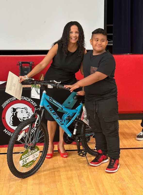 Ms. Trantham and student standing with his bike. 