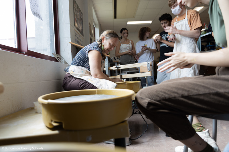 Ona Armstrong teaching pottery techniques to students. 